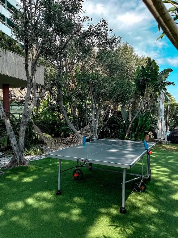 Tavolo da ping pong in giardino tra alberi e amaca