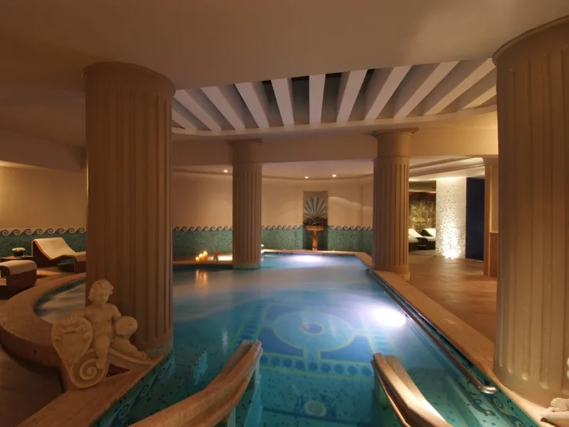 Piscina interna della spa con colonne classiche e illuminazione soffusa