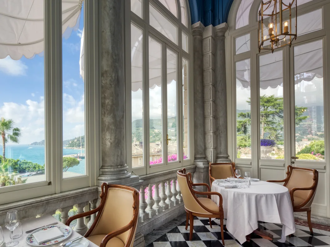Sala ristorante interna con grandi vetrate e colonne in marmo affacciate sul mare