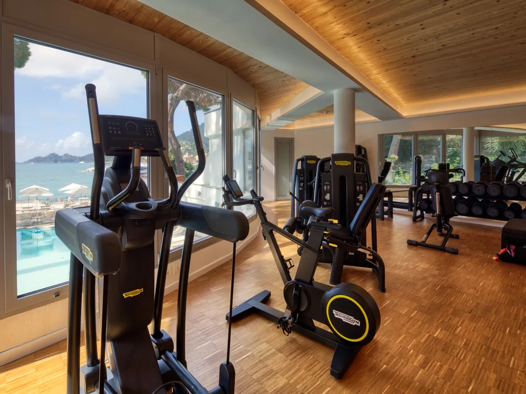 Palestra attrezzata con macchinari Technogym e ampie vetrate affacciate sulla piscina e sul mare