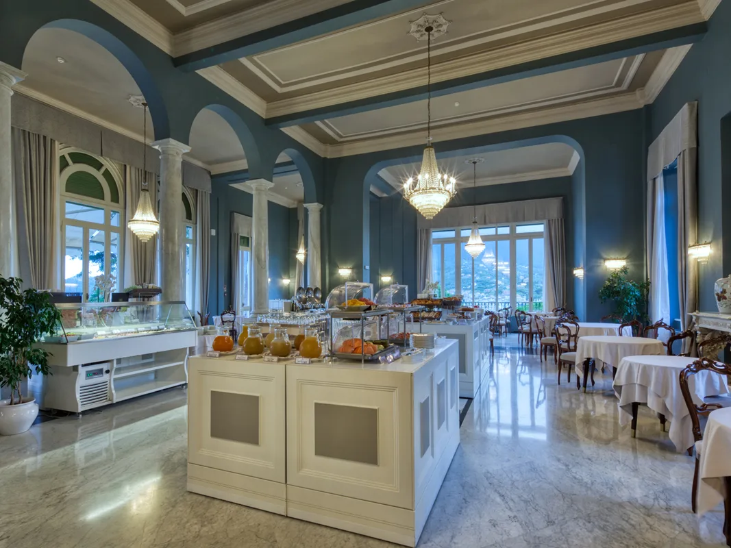 Sala colazione con isola buffet centrale, colonne e arredi classici in marmo