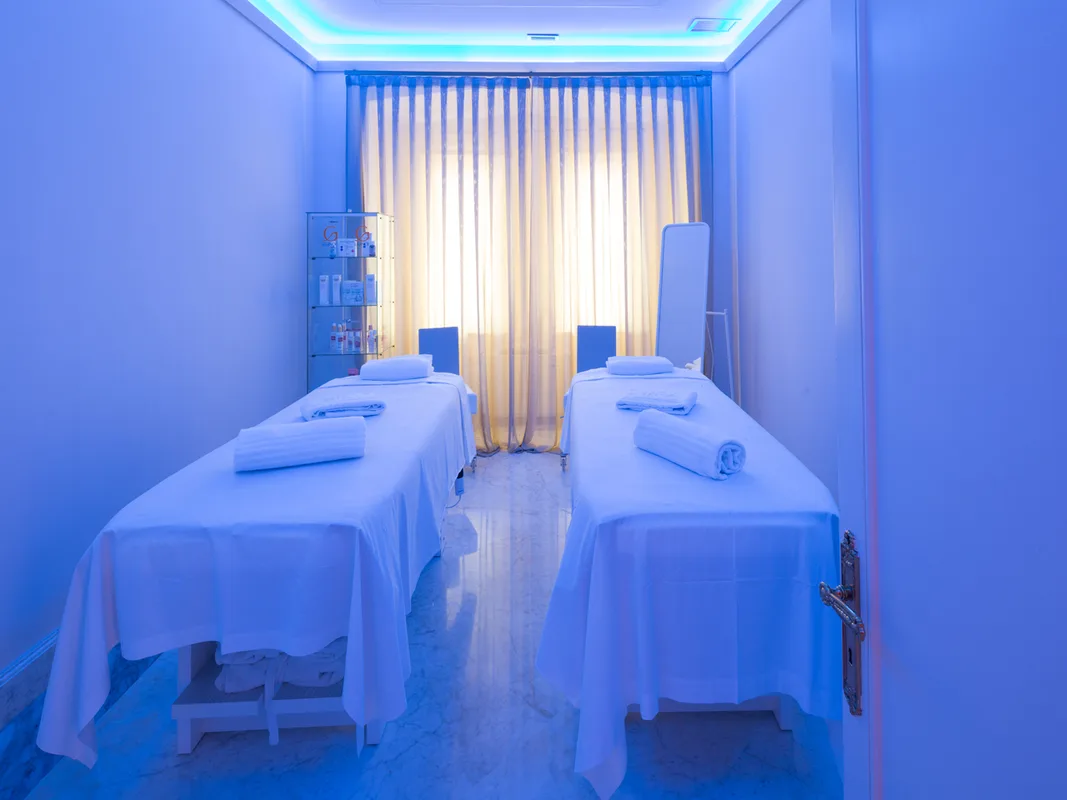 Cabina spa con due lettini per massaggi e illuminazione soffusa azzurra