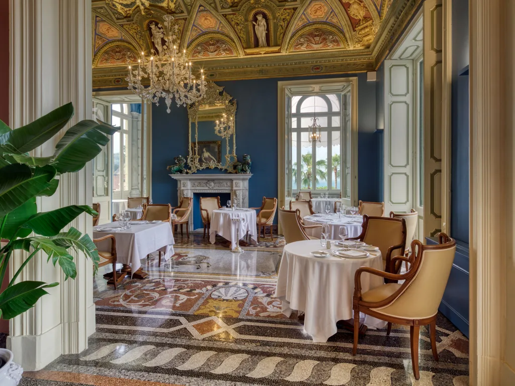 Elegante sala ristorante con soffitto affrescato, lampadario di cristallo e pavimento a mosaico