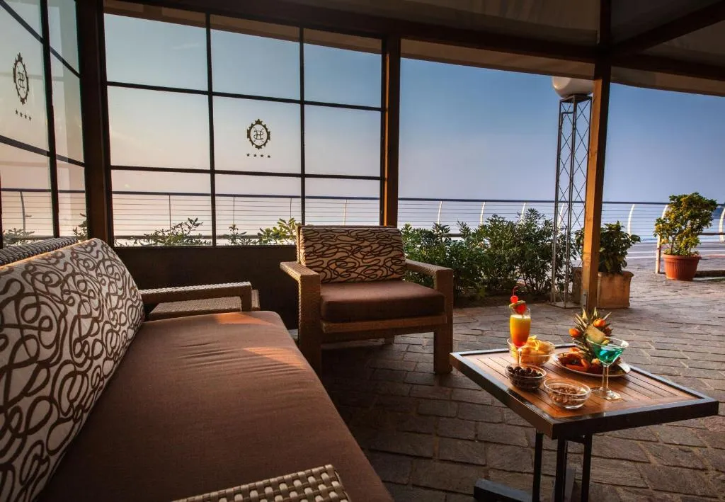 Salottino vista mare con divani e tavolino con aperitivo e frutta