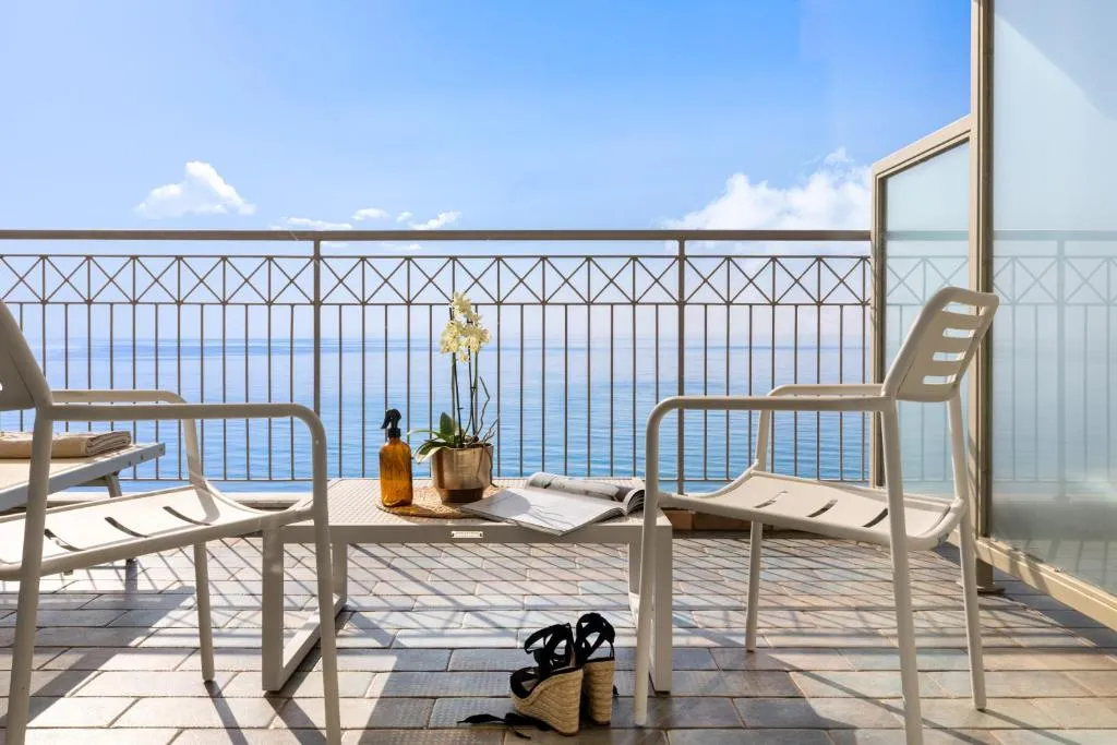 Balcone con poltrone bianche e vista sul mare azzurro
