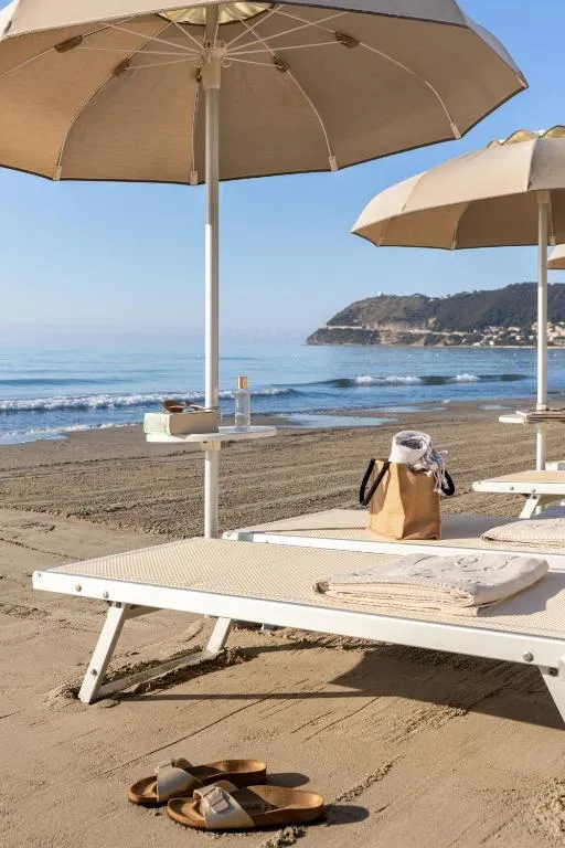 Lettino con ombrellone sulla spiaggia di sabbia con vista sul promontorio