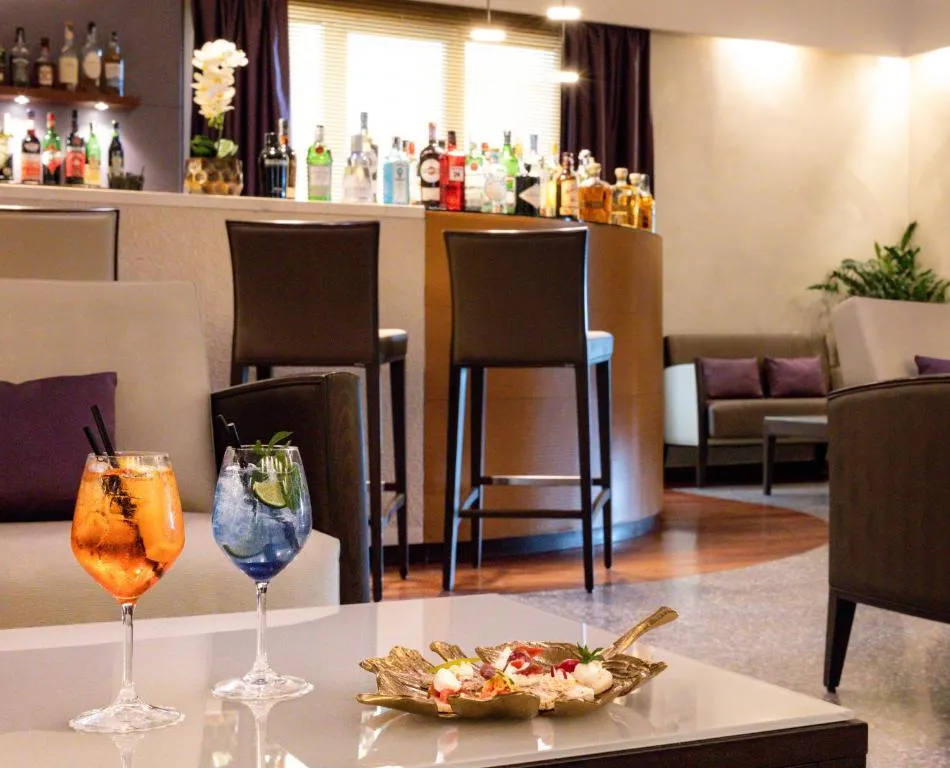 Bar lounge con cocktail colorati e bottiglie sullo sfondo