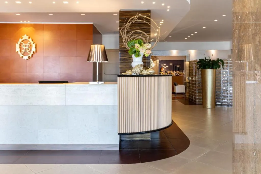 Hall dell'hotel con reception elegante in marmo e decorazioni floreali