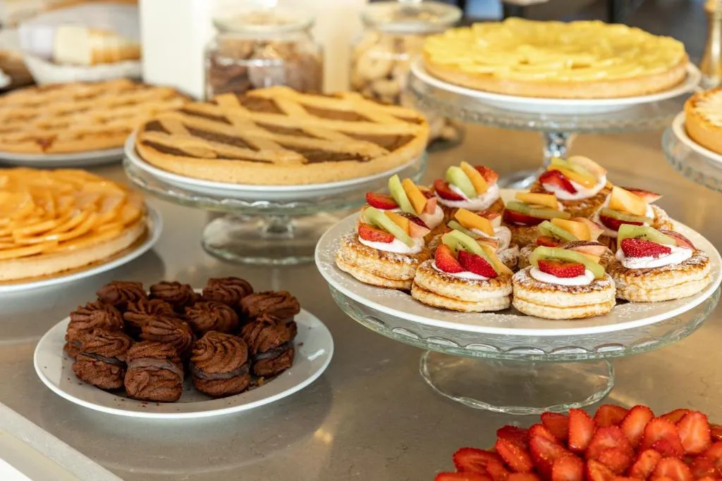 Buffet di dolci con crostate, pasticcini al cioccolato e frutta fresca
