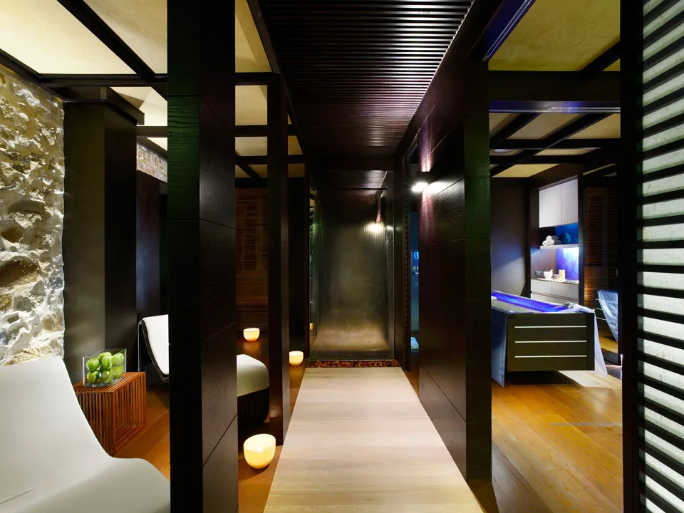 Corridoio della spa con design moderno in legno scuro, pietra e candele soffuse