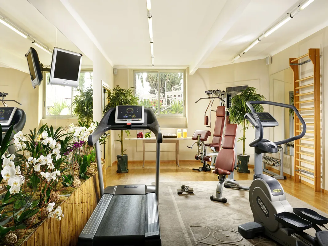 Palestra attrezzata con tapis roulant, macchinari fitness e piante ornamentali