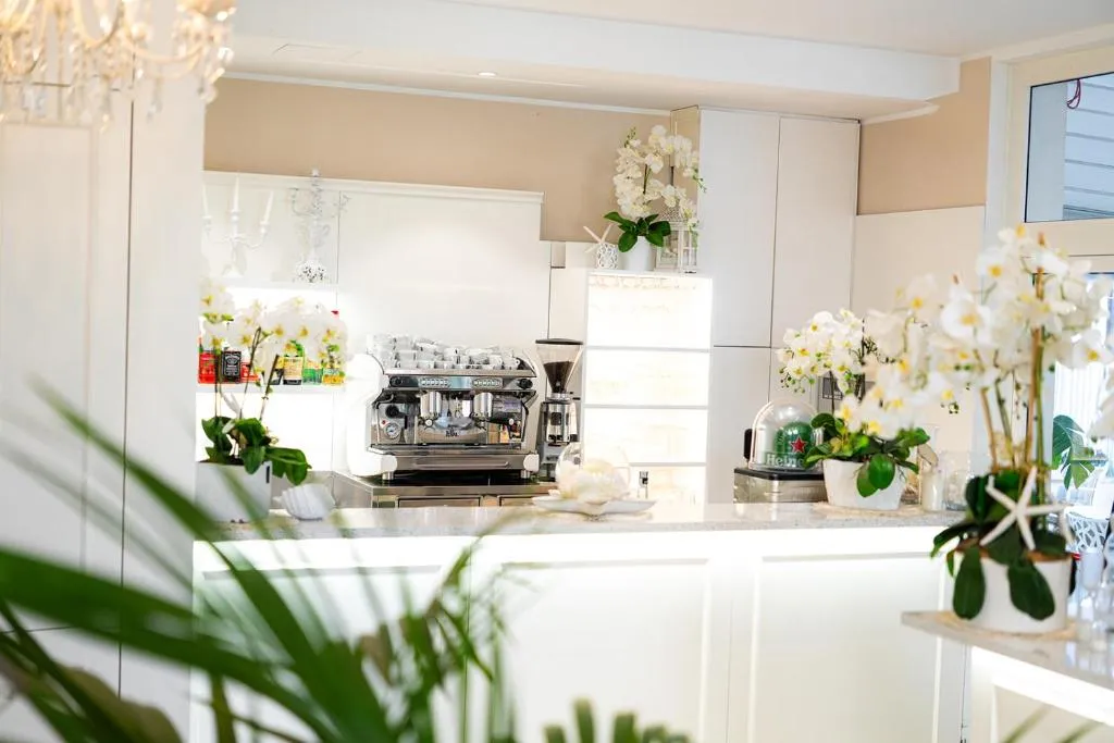 Bancone bar con macchina da caffè professionale e orchidee bianche