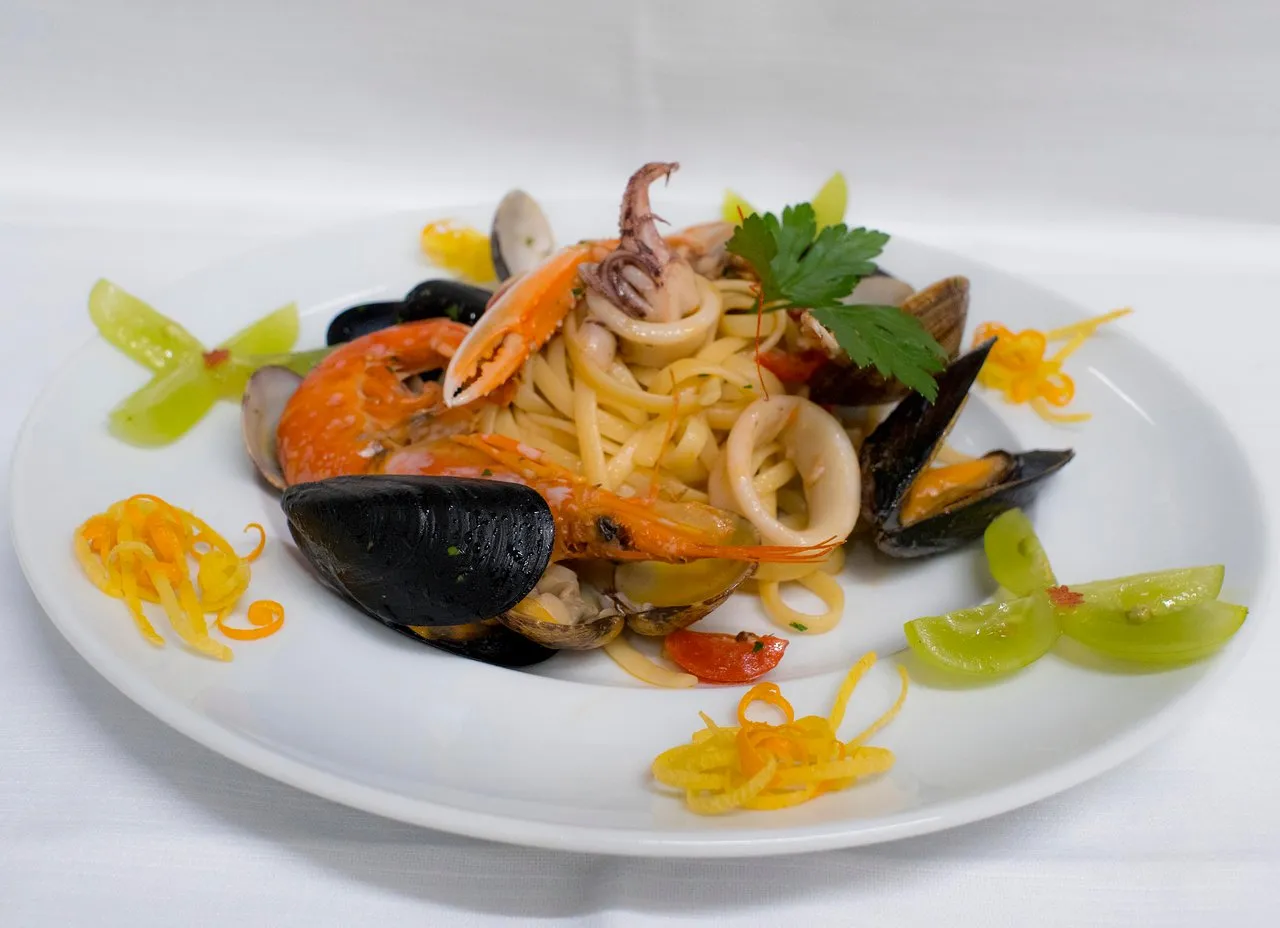 Piatto di linguine ai frutti di mare con cozze, gamberi e calamari