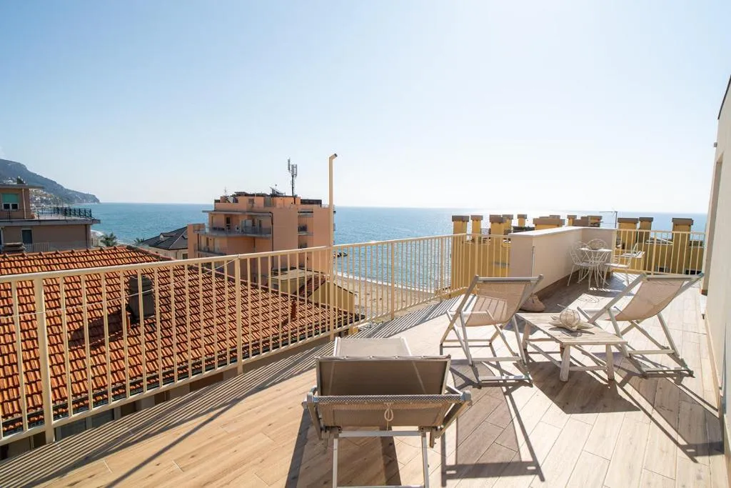 Ampia terrazza con sedie a sdraio, tavolino e vista sul mare