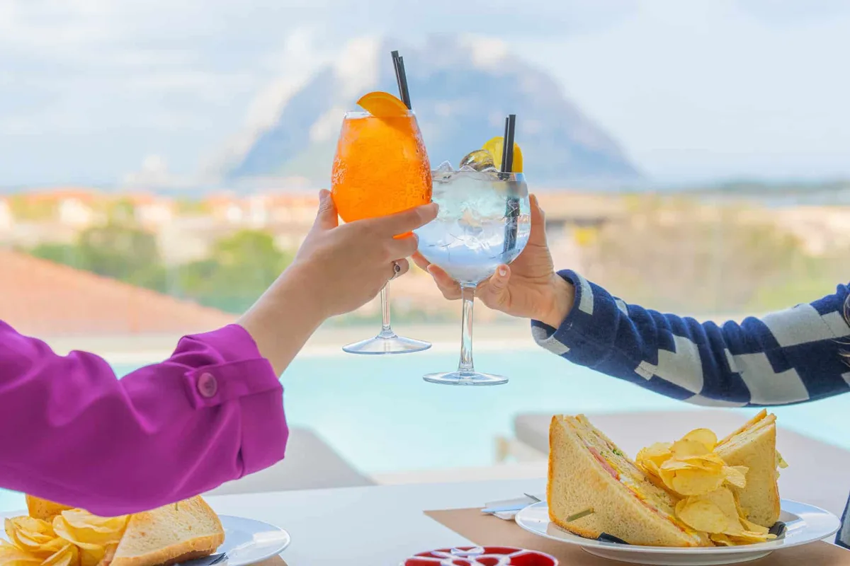 Brindisi con spritz e gin tonic e club sandwich con vista sull'Isola di Tavolara