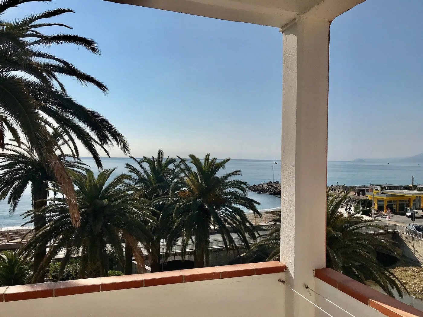 Vista sul mare e le palme dal balcone della camera dell'hotel