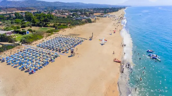 Vista aerea della spiaggia sabbiosa con ombrelloni e mare cristallino