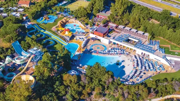 Vista aerea del parco acquatico con scivoli e piscine circondate da vegetazione