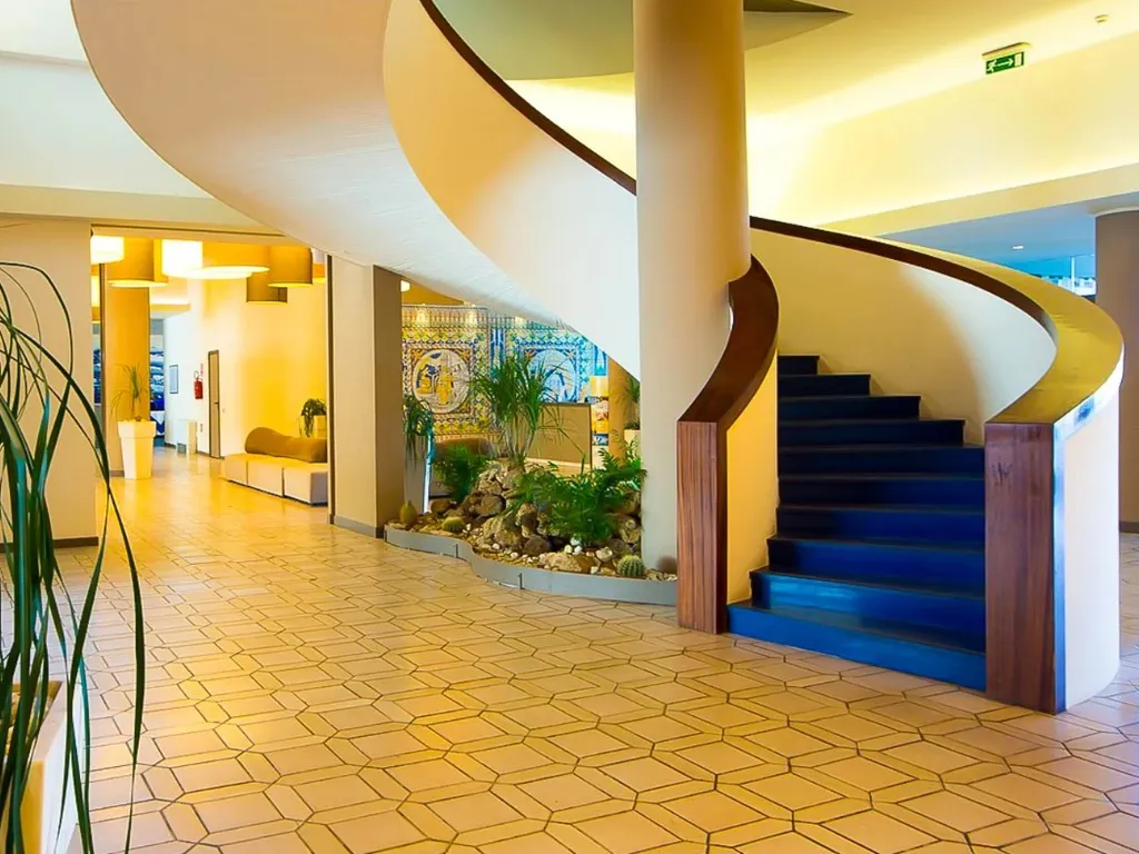 Hall dell'hotel con scala elicoidale e angolo verde decorativo
