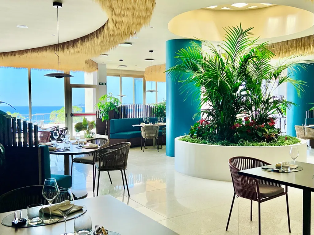 Sala ristorante moderna con piante tropicali e vista mare