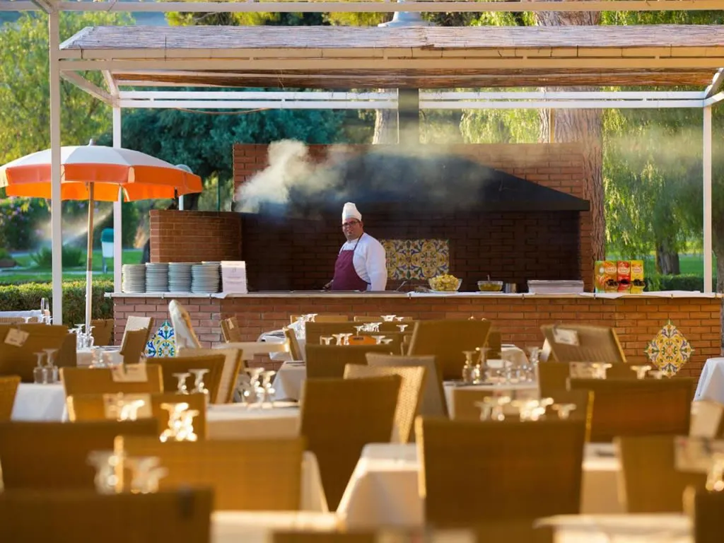 Ristorante all'aperto con griglia e chef al lavoro