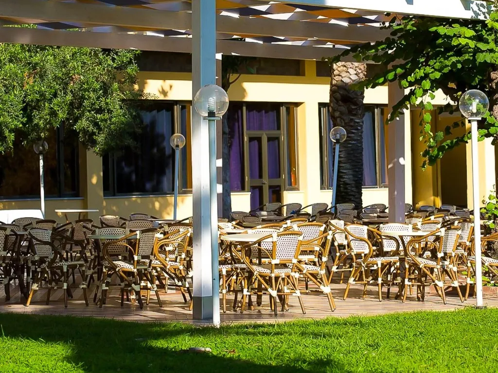 Terrazza esterna con tavolini e sedie in vimini nel giardino
