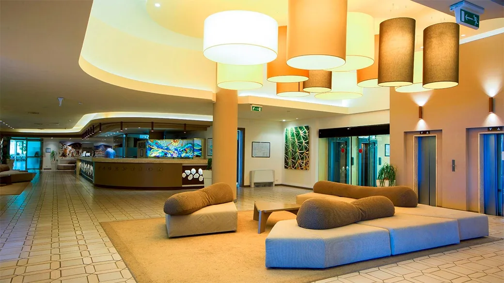 Hall dell'hotel con reception, divani moderni e lampade a sospensione