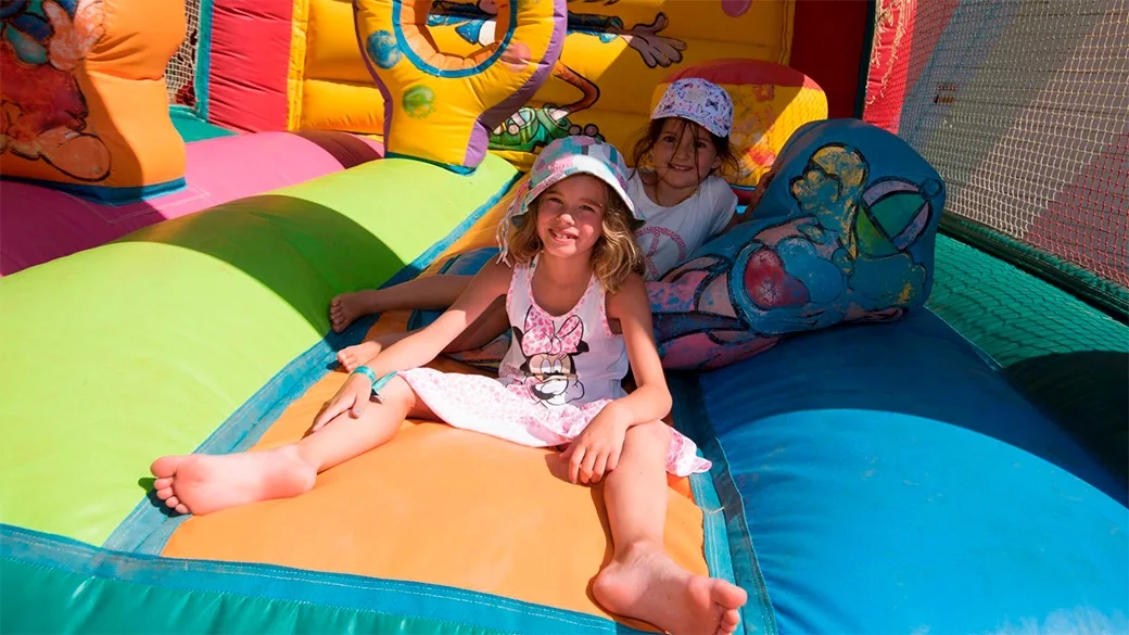Bambine che giocano felici su un gonfiabile colorato