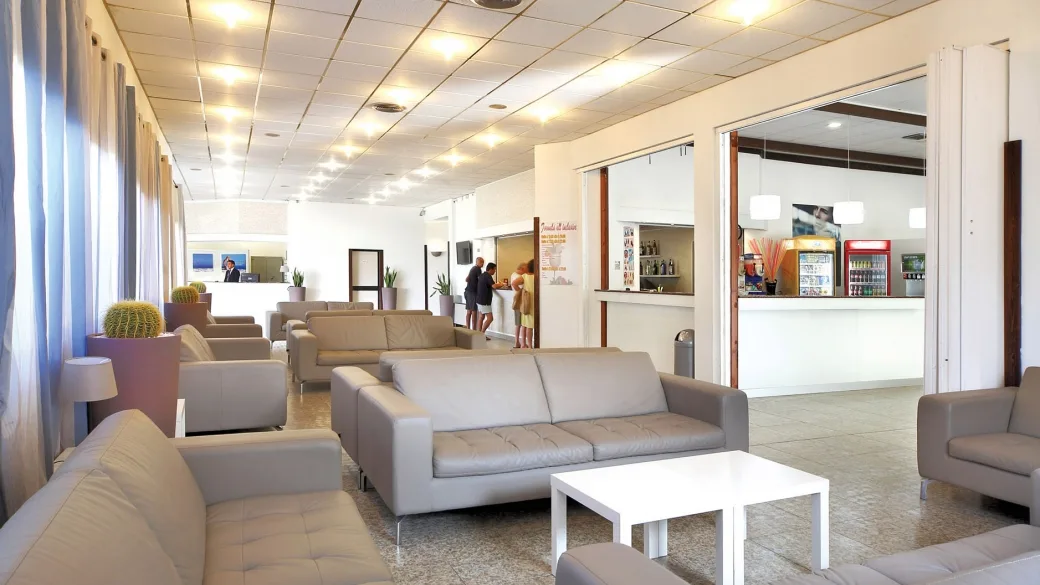 Hall dell'hotel con divani in pelle, reception e bar