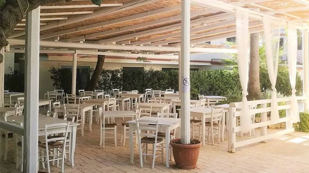 Veranda ristorante coperta con pergola in canne e tavoli bianchi