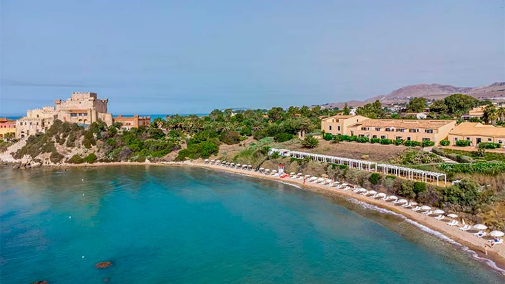 Veduta aerea della spiaggia con castello, lettini e mare cristallino