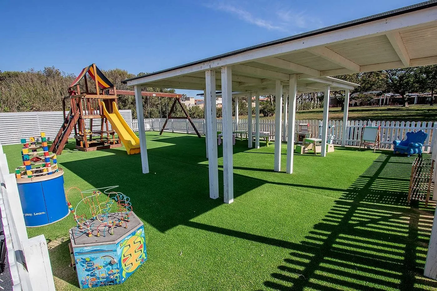 Area giochi per bambini con scivolo e prato verde