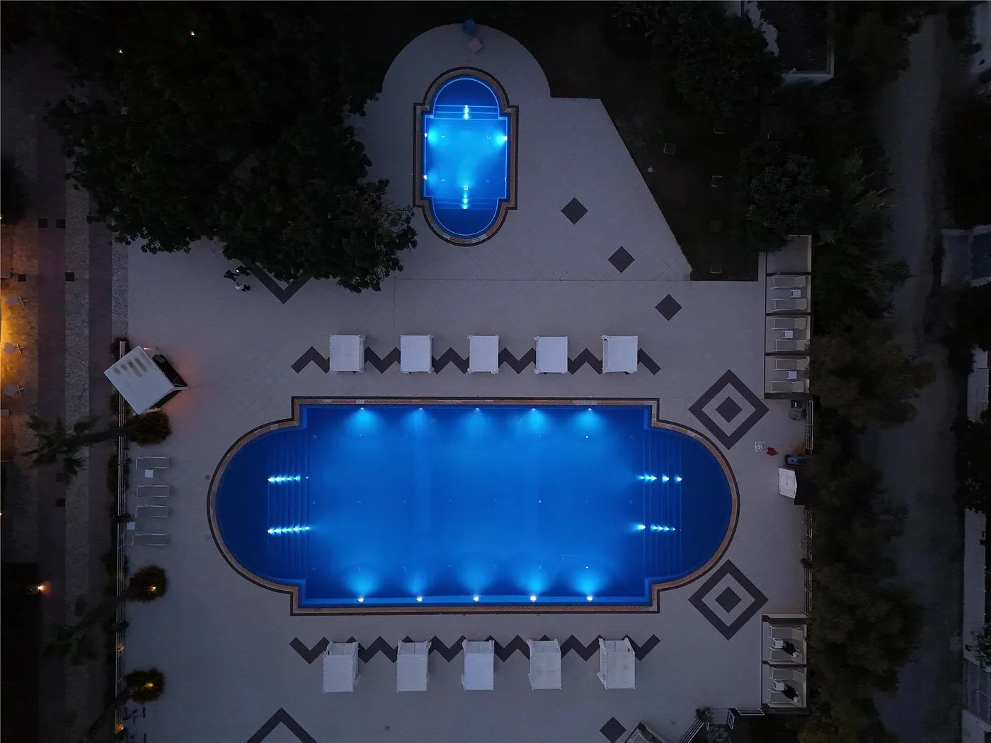 Vista dall'alto notturna delle due piscine illuminate di blu