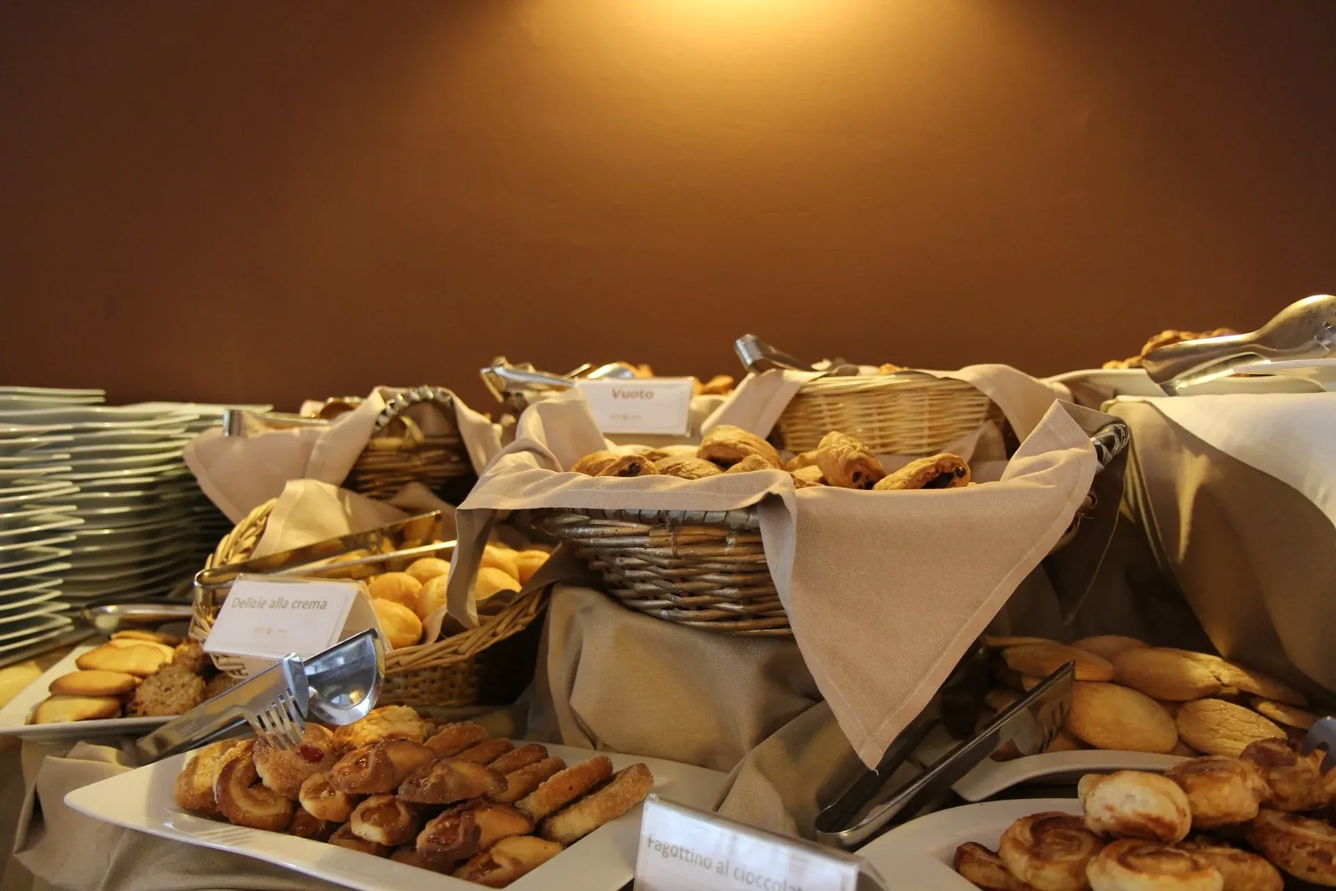 Buffet di colazione con cestini di pane e dolci