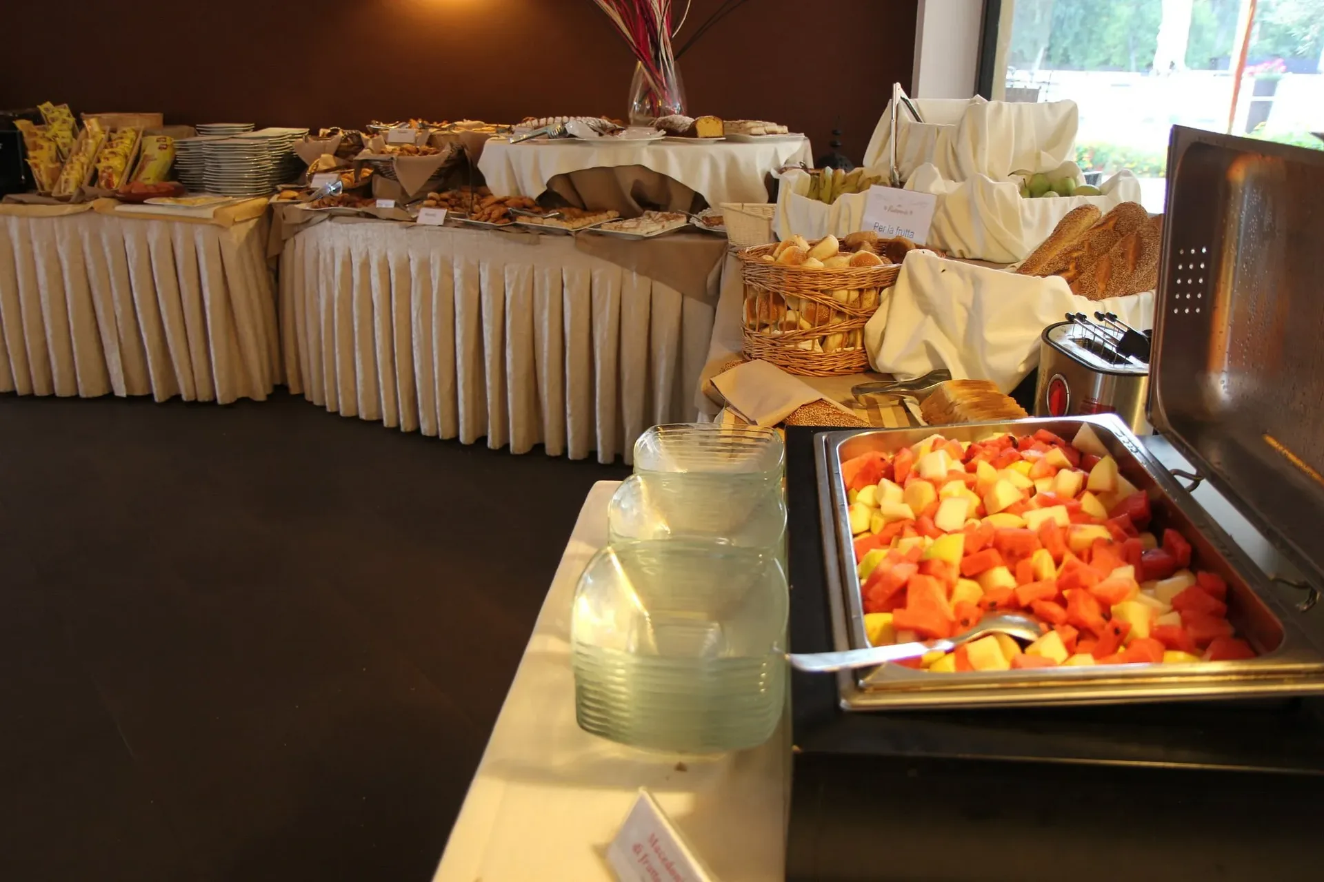 Buffet con macedonia di frutta, pane e dolci