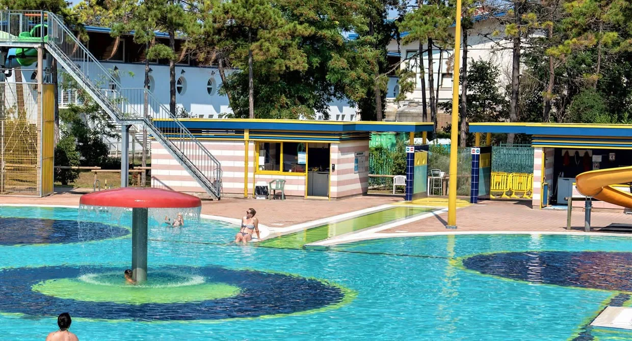 Area piscina con fontana a fungo, bar e strutture di servizio