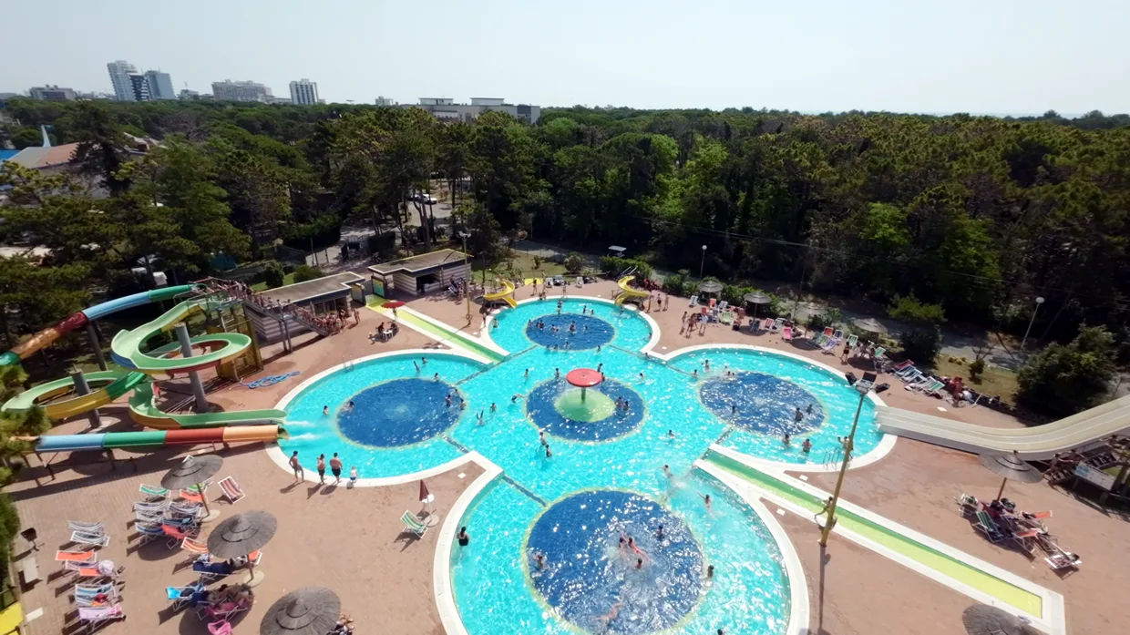 Vista aerea della grande piscina a forma di fiore con scivoli e lettini