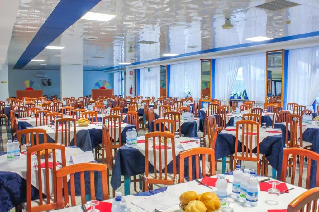 Sala ristorante con tavoli apparecchiati e sedie in legno