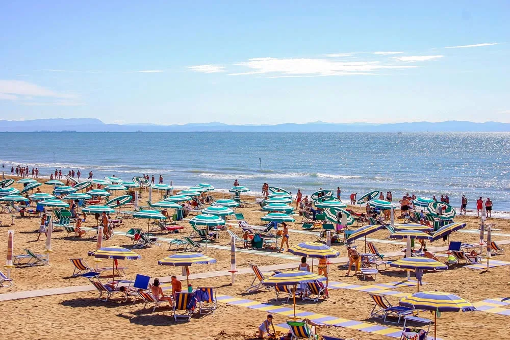 Spiaggia sabbiosa con ombrelloni e lettini davanti al mare