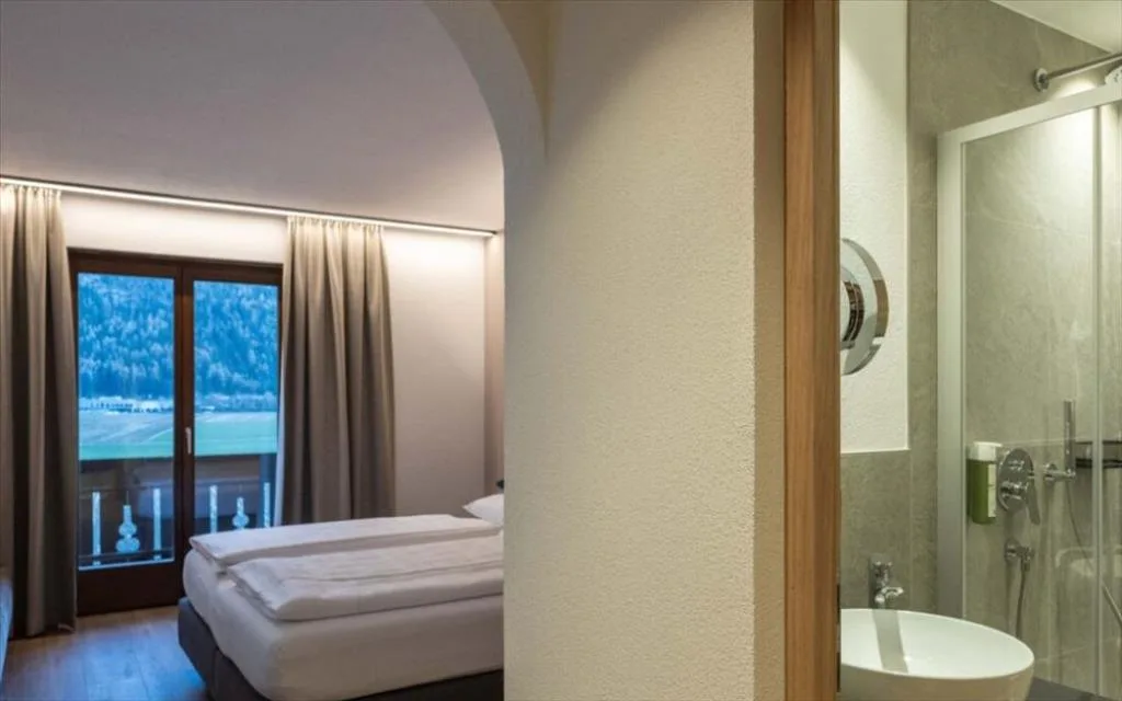 Camera con vista sulle montagne e bagno adiacente con doccia