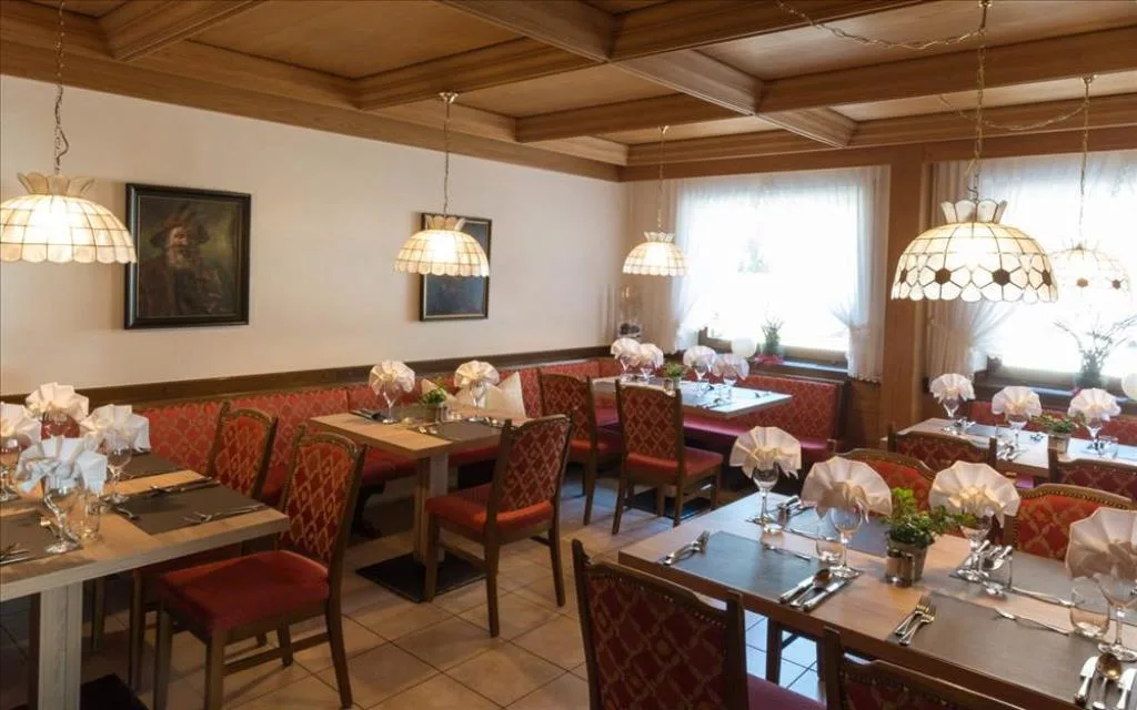Sala ristorante tradizionale con soffitto in legno e sedute rosse