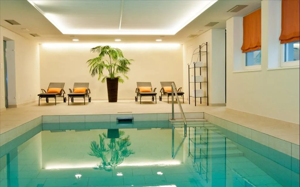 Piscina coperta con lettini e pianta ornamentale
