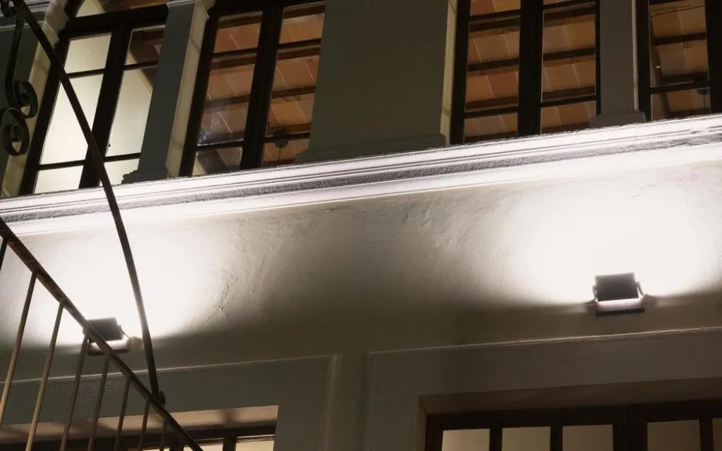 Dettaglio di facciata con balcone e faretti illuminati di notte