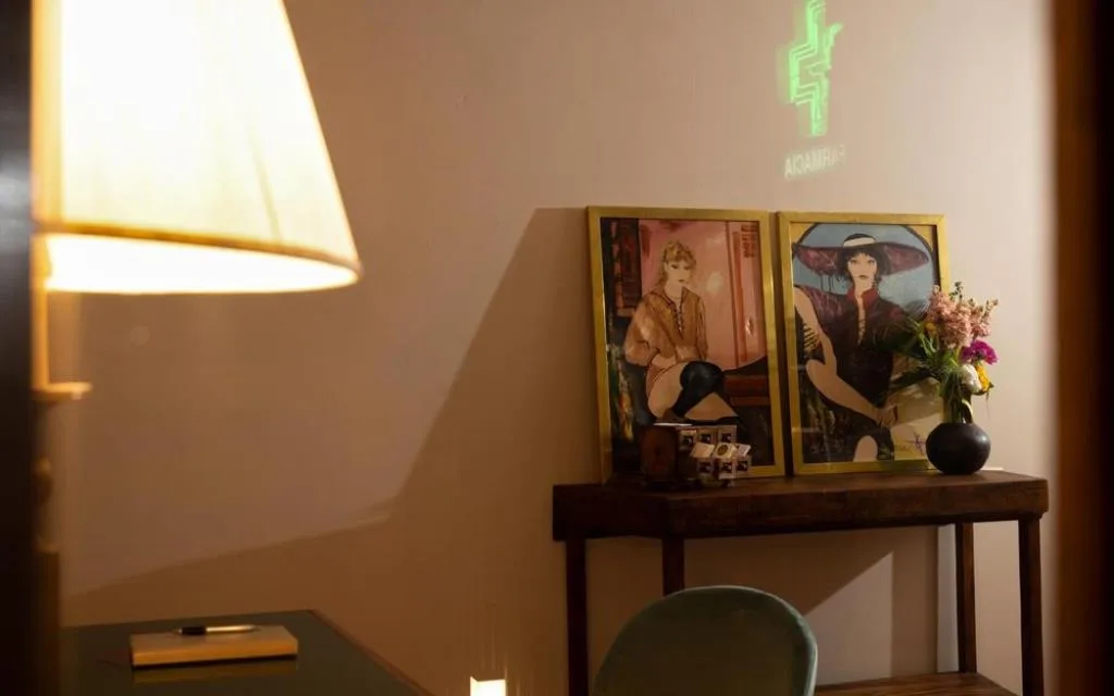 Angolo living con lampada, scrivania e quadri decorativi a parete