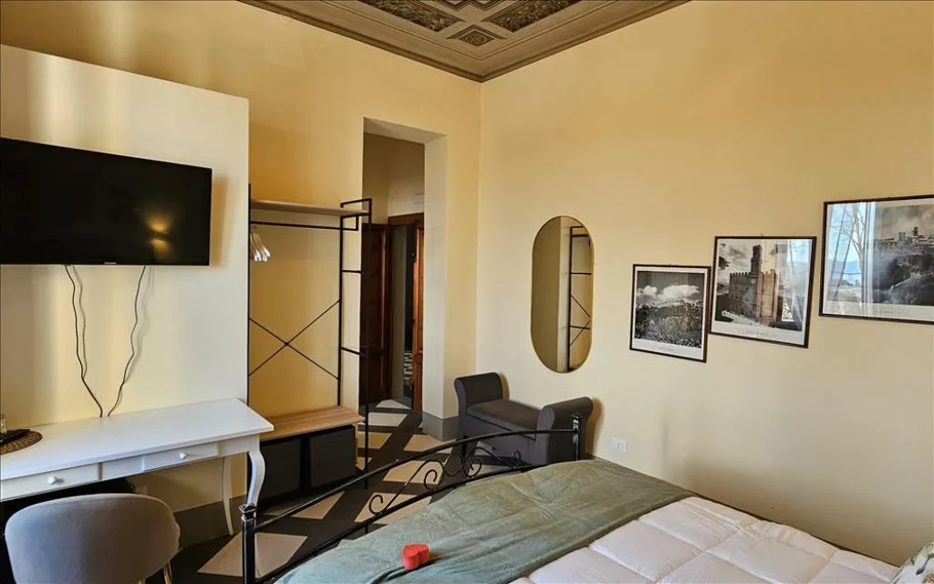 Camera con soffitto affrescato, TV a parete e quadri decorativi
