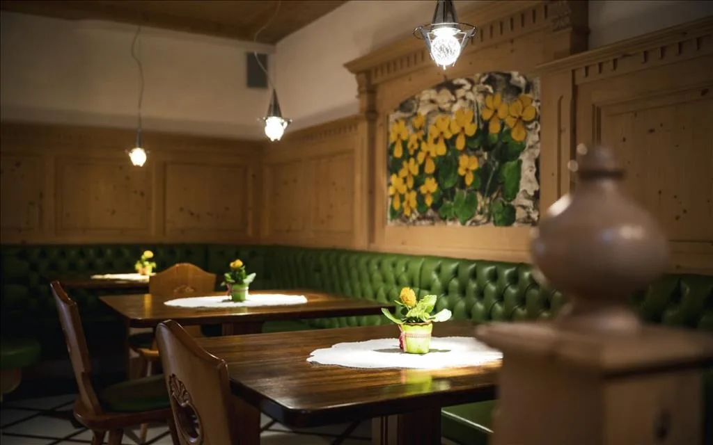 Sala interna in stile tradizionale con boiserie in legno e divani verdi