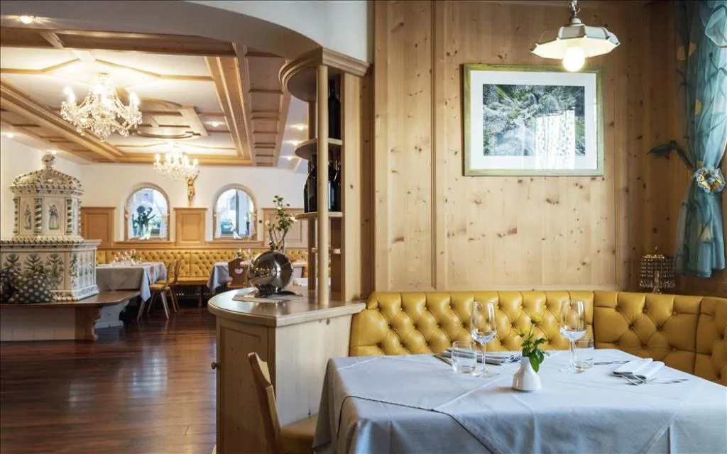 Sala da pranzo con stufa in ceramica decorata e arredi in legno chiaro