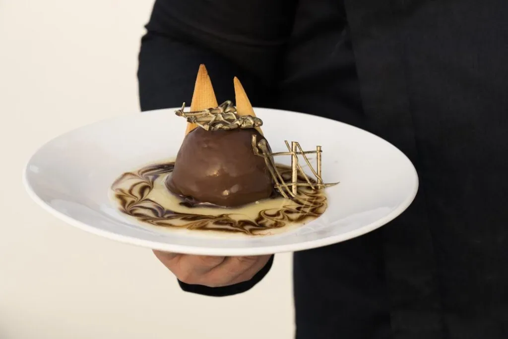 Dessert al cioccolato con decorazioni servito su piatto bianco