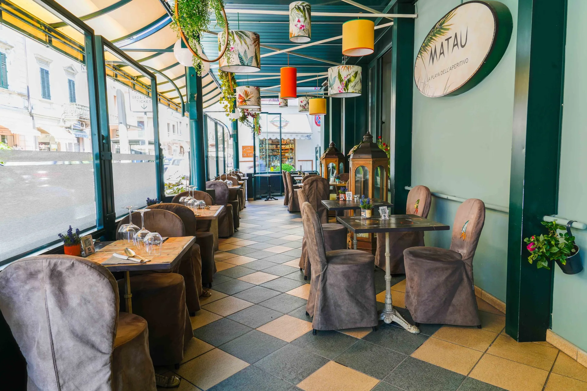 Sala interna del ristorante Matau con tavoli apparecchiati e lampade colorate