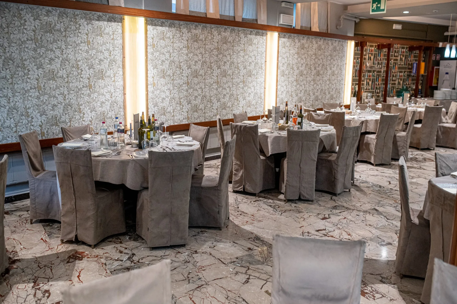 Sala ristorante per eventi con tavoli rotondi eleganti e pavimento in marmo